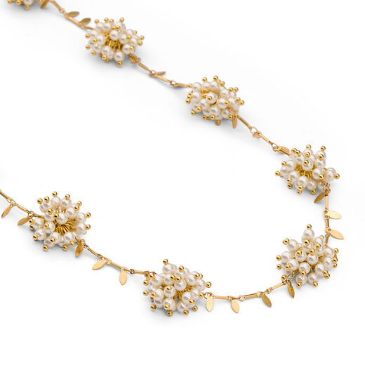 Detail of a necklace with clusters of white faux pearls.